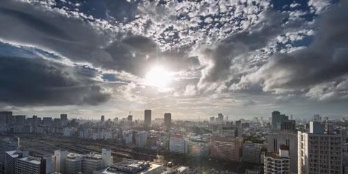 Photo aérienne d'une ville avec building, nuages et soleil