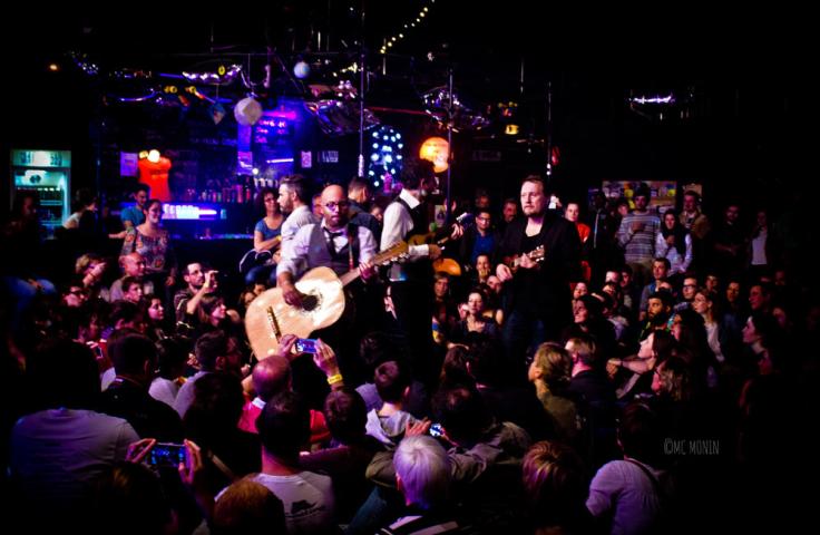 Homme jouant de la guitare au milieu d'une foule