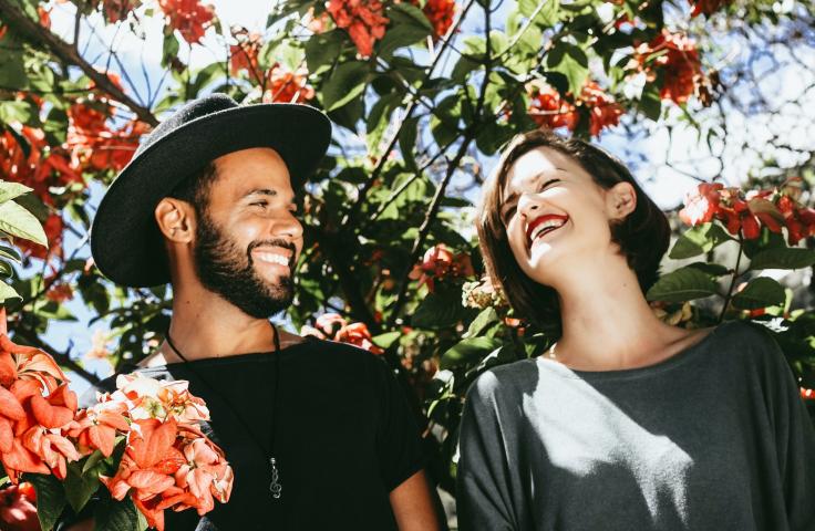 Deux personnes riant avec des fleurs autour