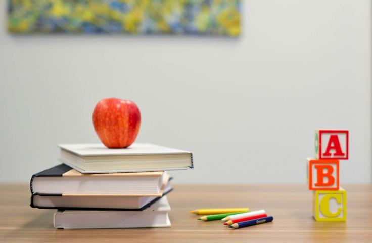 Livres d'écoles empilés avec une pomme au dessus