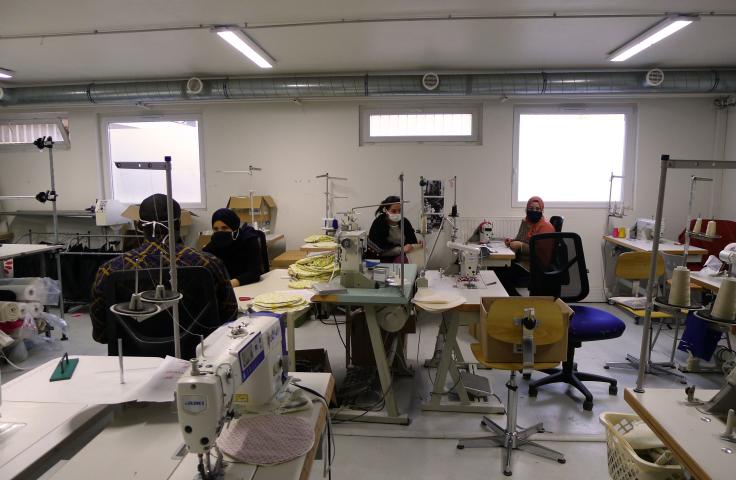 hommes et femmes faisant de la couture dans un atelier