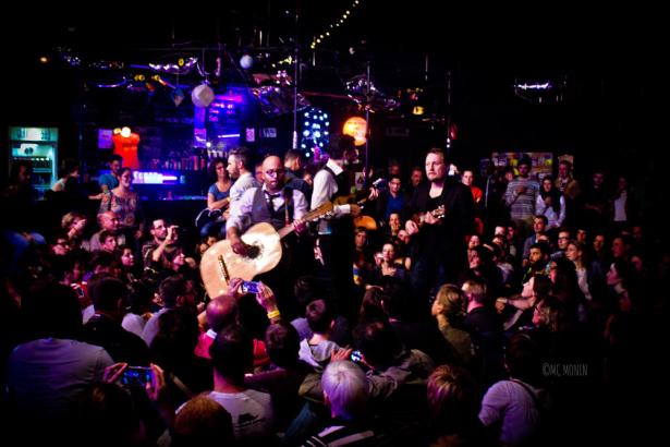 Homme jouant de la guitare au milieu d'une foule