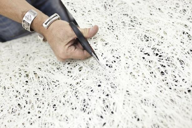 Personne découpant un tissu avec des ciseaux