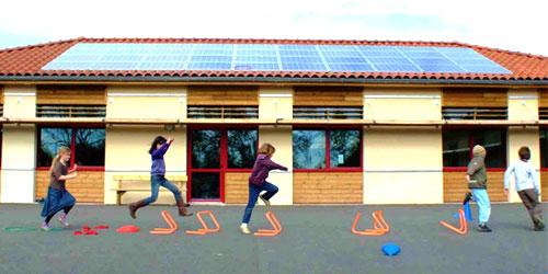 Enfants jouant devant un bâtiment avec panneaux solaires