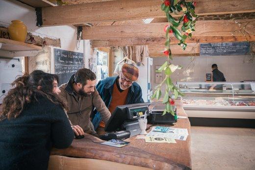 Trois personnes derrière la caisse d'un magasin