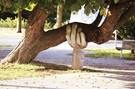Soutenez-nous_0.jpg une main en bois soutien un tronc d'arbre